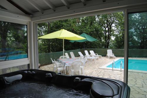 a swimming pool with a table and chairs and an umbrella at saint trome in Espinas