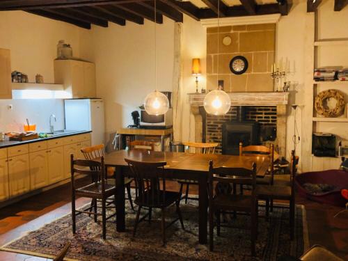 - une cuisine et une salle à manger avec une table et des chaises dans l'établissement Au Coeur des Vignes, à Pouillé
