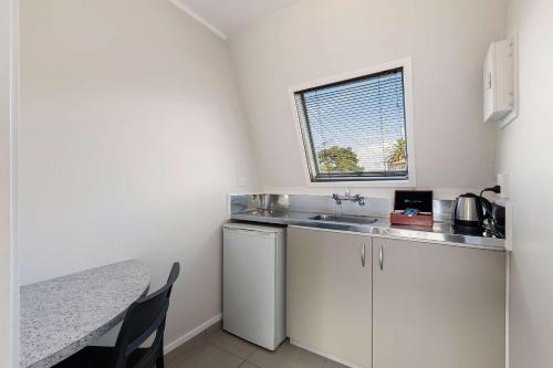 a small kitchen with a sink and a table at The Parnell Hotel & Conference Centre in Auckland