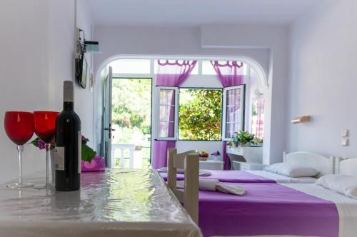 a dining room with a table with a bottle of wine at Apart Hotel Blumarin in Agios Gordios