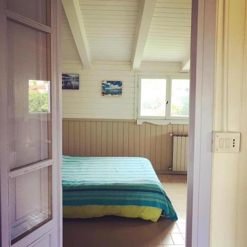 a bedroom with a bed in a room with two windows at Lo Chalet dell'Artista in Torre del Lago Puccini