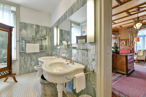 een witte badkamer met een wastafel en een douche bij Hotel Park Villa in Schaffhausen