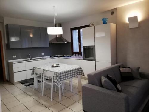 a kitchen and living room with a table and a couch at CINZIA E ROLDANO in Torri di Quartesolo