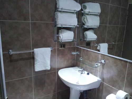 a bathroom with a sink and a toilet and towels at Hotel Astore Suites in Antofagasta