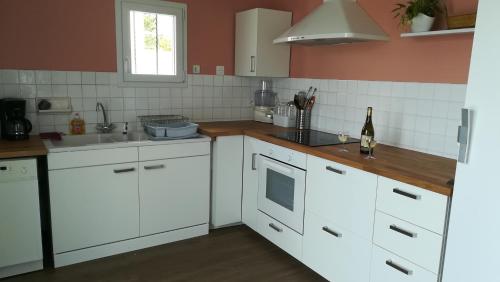 uma cozinha com armários brancos e um lavatório em Maison vent ouest em Saint-Michel-Chef-Chef