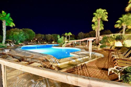 a swimming pool in a resort at night at U FARNIENTE in Bonifacio