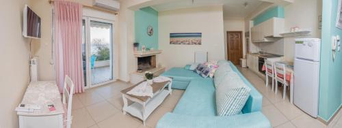 a living room with a blue couch and a kitchen at Boutique Apartment Volos in Volos