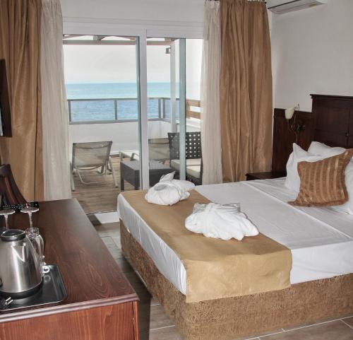 a bedroom with a bed and a view of the ocean at Paralia Beach Boutique Hotel in Paralia Katerinis