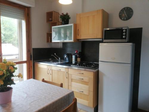 a small kitchen with a white refrigerator and a table at La Terrazza in Vaglia