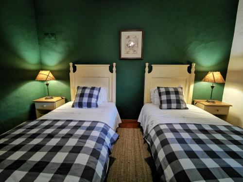 two beds in a room with green walls at Monte Alerta Turismo Rural in Monsaraz