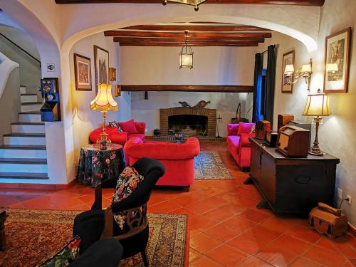 a living room with red couches and a fireplace at Monte Alerta Turismo Rural in Monsaraz