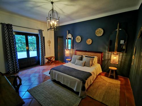 a bedroom with a bed and a blue wall at Monte Alerta Turismo Rural in Monsaraz
