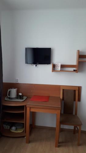 - un bureau avec une télévision et une table avec une chaise dans l'établissement Pokoje gościnne Busko-Zdrój, à Busko-Zdrój