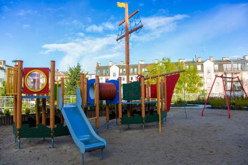 einen Spielplatz mit verschiedenen farbigen Spielgeräten in einem Park in der Unterkunft Wyspa Uznam - Kwartał Róży Wiatrów in Świnoujście