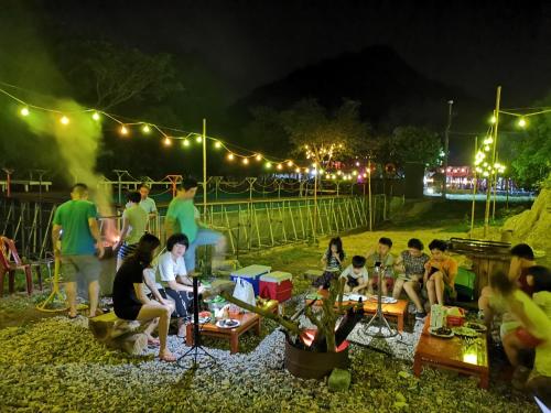 eine Gruppe von Menschen, die nachts in einem Park sitzen in der Unterkunft Cat Ba Eco Lodge Resort in Cát Bà