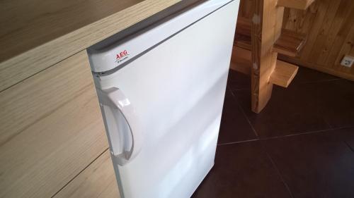 a white refrigerator freezer sitting on top of a floor at Mikalojiškis in Inturkė