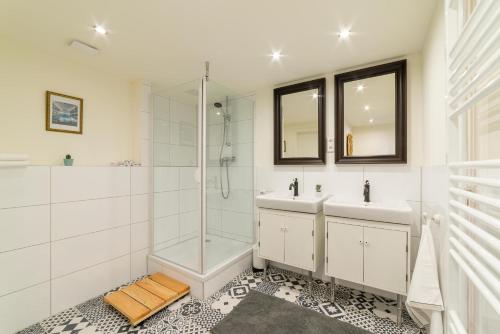 uma casa de banho com 2 lavatórios e um chuveiro em Bürgerpark Apartments em Berlim