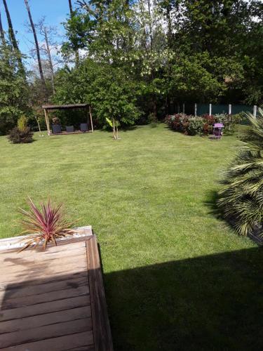 a garden with a gazebo in the middle of a yard at Chambre d'hôtes les Iris à Mios sur le Bassin d'Arcachon in Mios