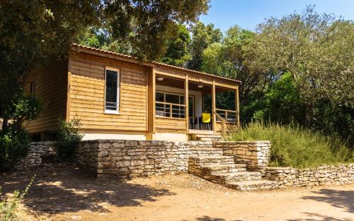 a small wooden house with a stone wall at U FARNIENTE in Bonifacio