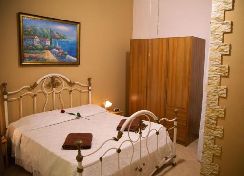 バレストラーテにあるIl Girasoleの白いベッドと木製キャビネット付きのベッドルーム1室が備わります。