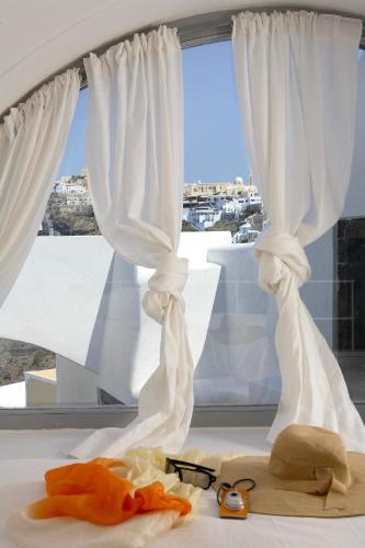 a pair of glasses sitting on a table in front of a window at Blue Angel Villa in Fira
