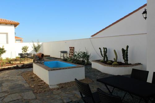 een patio met een zwembad en een tafel en stoelen bij Casa Rural El Nidal in Casas de Don Pedro