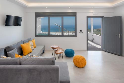 sala de estar con sofá y vistas al océano en Belle Etoile Villas, en Imerovigli