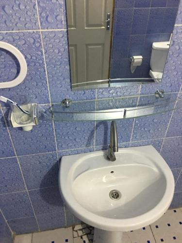 a bathroom with a sink and a mirror at La kora in Toubakouta