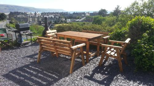 a wooden table and two chairs sitting next to a table at Apartment Chic in Barmouth
