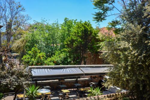 a patio with tables and chairs and trees at Otel Wood House in Antalya