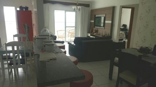 cocina y sala de estar con mesa y sillas en Lindo apartamento bairro Aviação, en Praia Grande