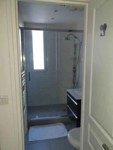 une salle de bain avec une douche, des toilettes et un lavabo dans l'établissement Beautiful Lincoln Apartment, à Paris