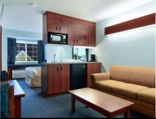 a living room with a couch and a kitchen at Microtel Inn & Suites by Wyndham Gardendale - Birmingham North in Gardendale