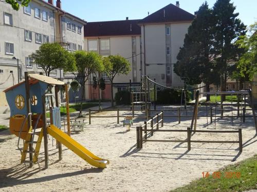 an empty playground with a yellow slide in the sand at La Casa de Pepa a 1,5 Km de la Catedral in Santiago de Compostela