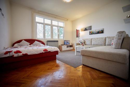 a bedroom with a bed and a couch at Central Tuzla apt - free parking in Tuzla