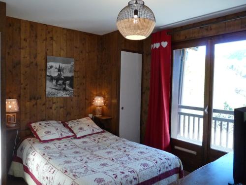 1 dormitorio con cama y ventana grande en Le Bourjaillet, en Notre-Dame-de-Bellecombe