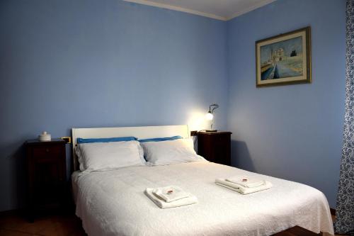 1 dormitorio azul con 1 cama con 2 toallas en Il Gelsomino Assisi, en Palazzo
