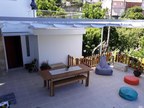 a patio with a wooden bench and an umbrella at Casa da Padaria in Folgosa