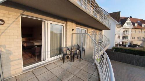 einen Balkon mit einem Tisch und Stühlen darauf in der Unterkunft Hotel Arcato in De Haan