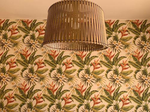 a chandelier hanging from a wall with a floral wallpaper at Hotel Caribe - Garda Lake Collection in Brenzone sul Garda