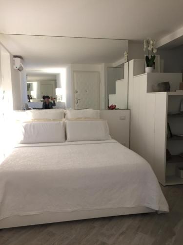 1 dormitorio con cama blanca y almohadas blancas en La Porta Bianca, en Trieste
