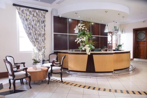 a lobby with a reception desk and chairs at Britannia Hotel in Durban