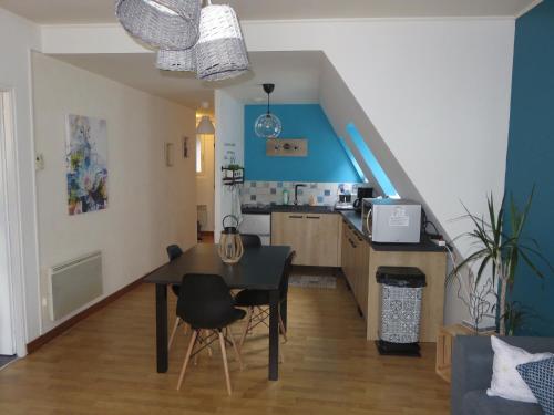 een woonkamer met een tafel en een keuken bij Grand appartement chaleureux in Thouars