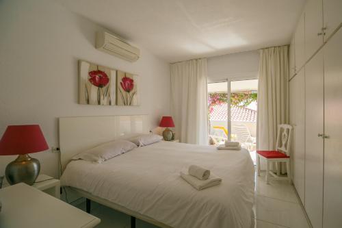 Un dormitorio con una cama blanca con dos toallas encima. en Bungalow Claire, en Callao Salvaje