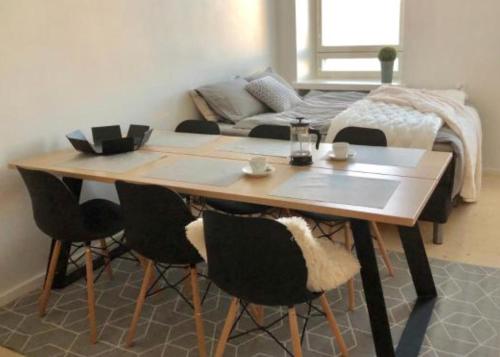 a dining room table with chairs and a couch at Scandinavian Sweet home 18 Heart of City in Helsinki