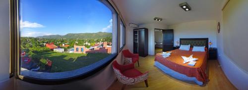 a room with a bedroom with a large window at Complejo Namaste in San Antonio de Arredondo