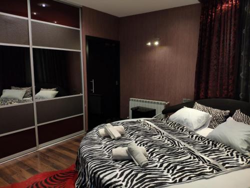 a zebra print bed in a bedroom with a mirror at Nizami Apartment in Baku
