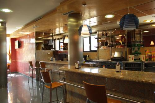 un bar en un restaurante con barra y sillas en Hostal Tio Pepe II en Bembibre