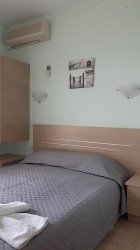 a bedroom with a bed with a blue comforter at Ntemos Apartments in Tolo