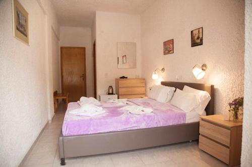 a bedroom with a large bed with purple sheets at Gioma Hotel in Agia Galini